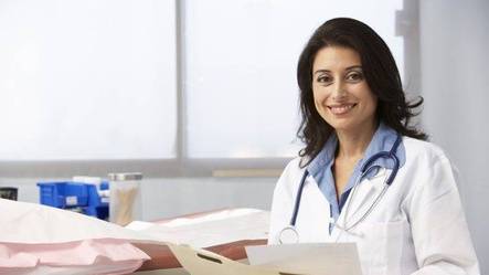 Doctor smiling while looking over charts and notes